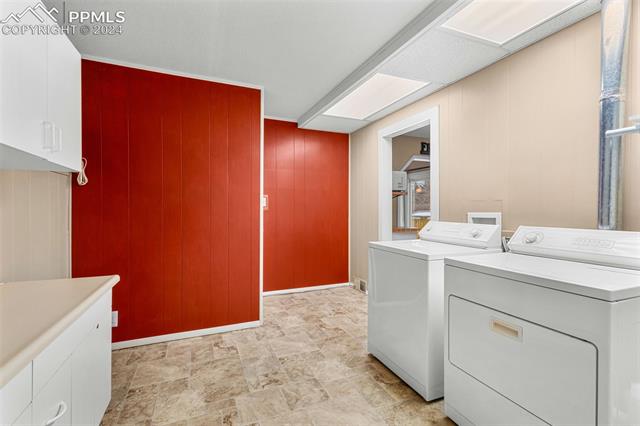 2125 Winston Road Colorado Springs, CO 80909 - Photo 17 of 37 Laundry room featuring cabinets, separate washer and dryer, and light tile floors
