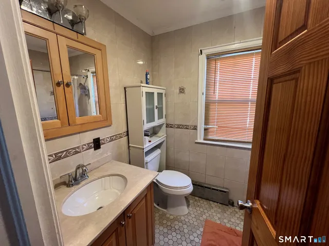 a bathroom with a granite countertop sink toilet and mirror