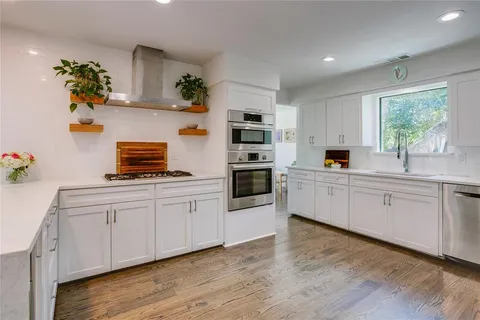 a kitchen with cabinets a window and appliances