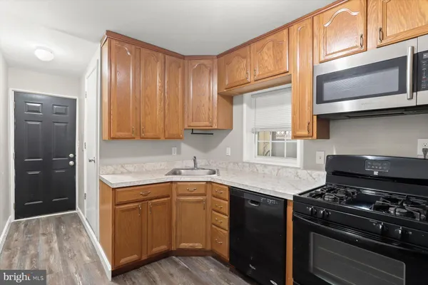 a kitchen with stainless steel appliances granite countertop a sink stove and cabinets