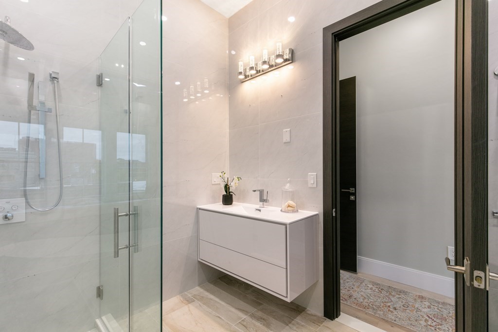 88 Dover Street, Unit 2 Somerville, MA 02144 - Photo 24 of 36 a bathroom with a double vanity sink a mirror and shower