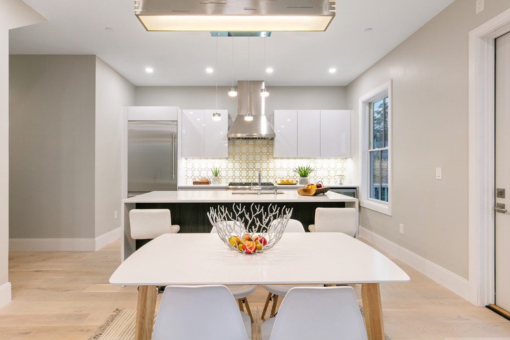 88 Dover Street, Unit 2 Somerville, MA 02144 - Photo 7 of 36 a room with stainless steel appliances kitchen island a table and chairs in it