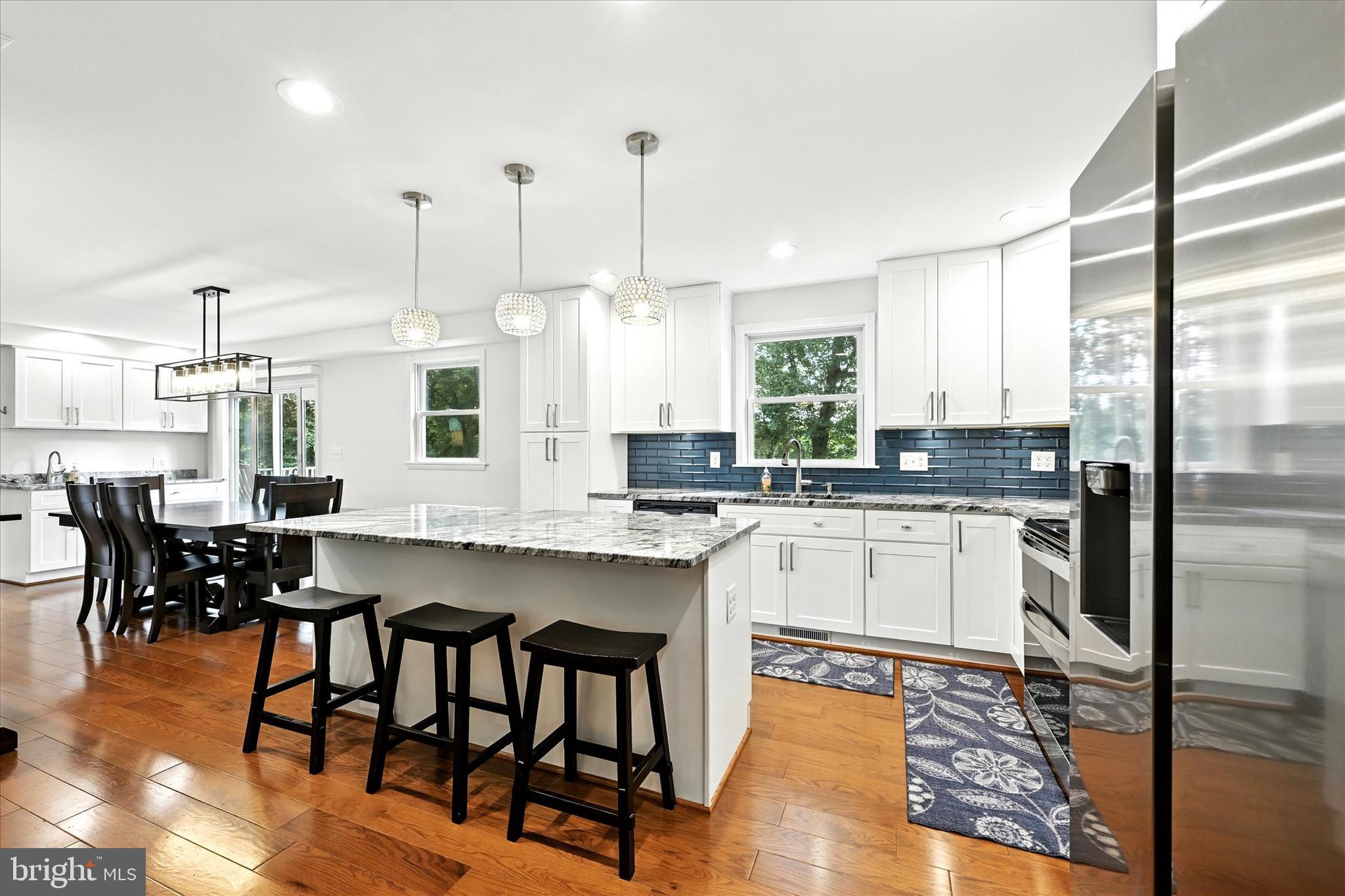 3111 Northwind Road Baltimore, MD 21234 - Photo 13 of 81 a kitchen with stainless steel appliances granite countertop a stove a sink a refrigerator a dining table and chairs with wooden floor