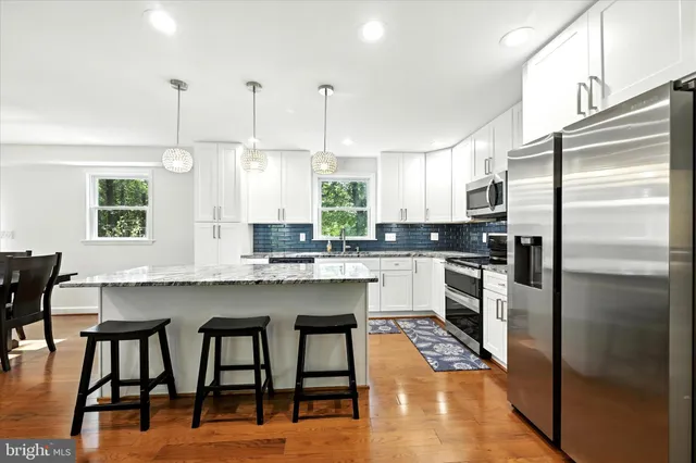 a kitchen with kitchen island a counter top space stainless steel appliances and cabinets