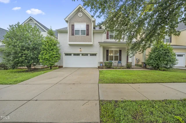 a front view of a house with a yard and trees