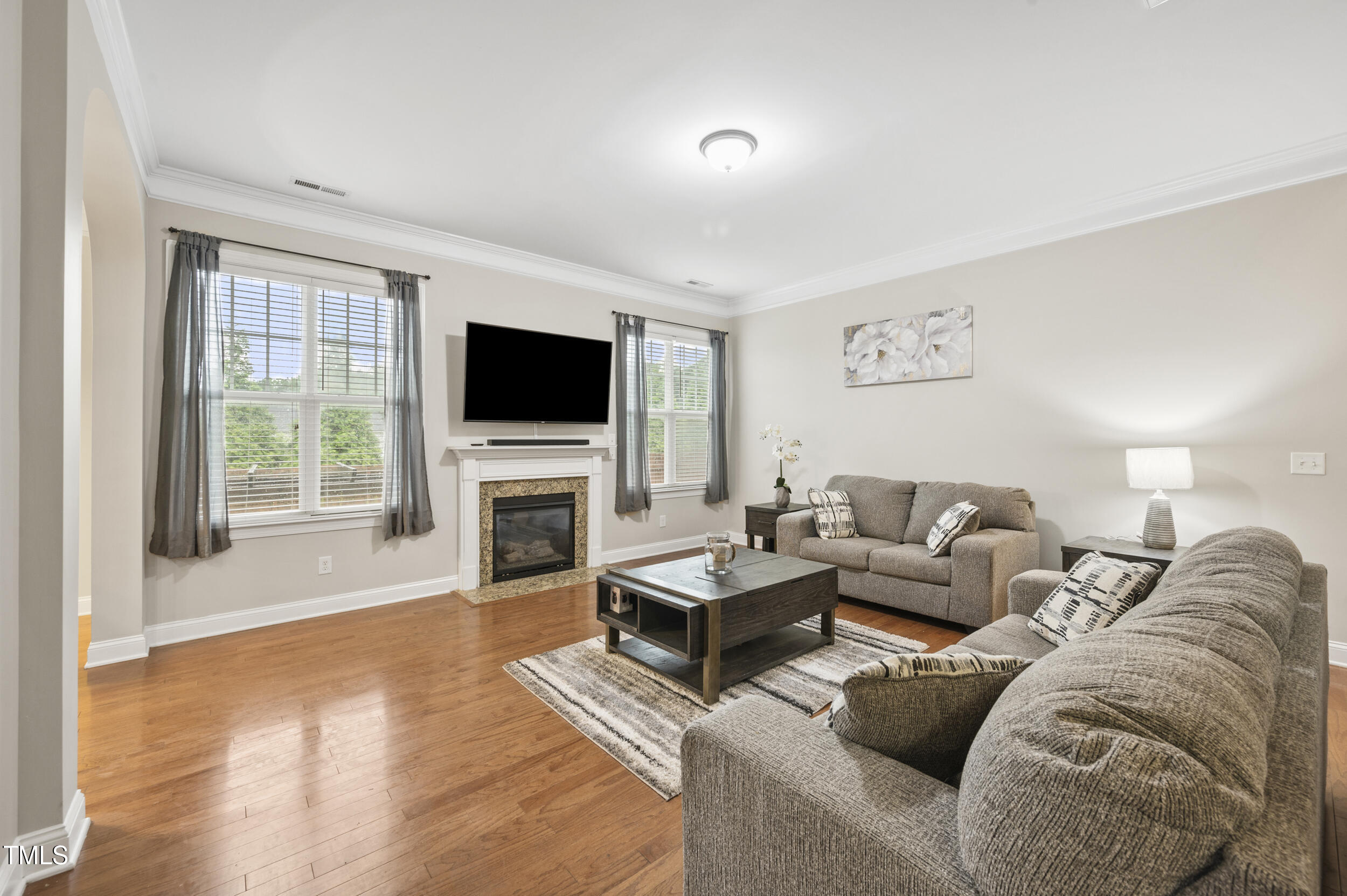 1204 Chapanoke Road Raleigh, NC 27603 - Photo 11 of 45 a living room with furniture a fireplace and a flat screen tv