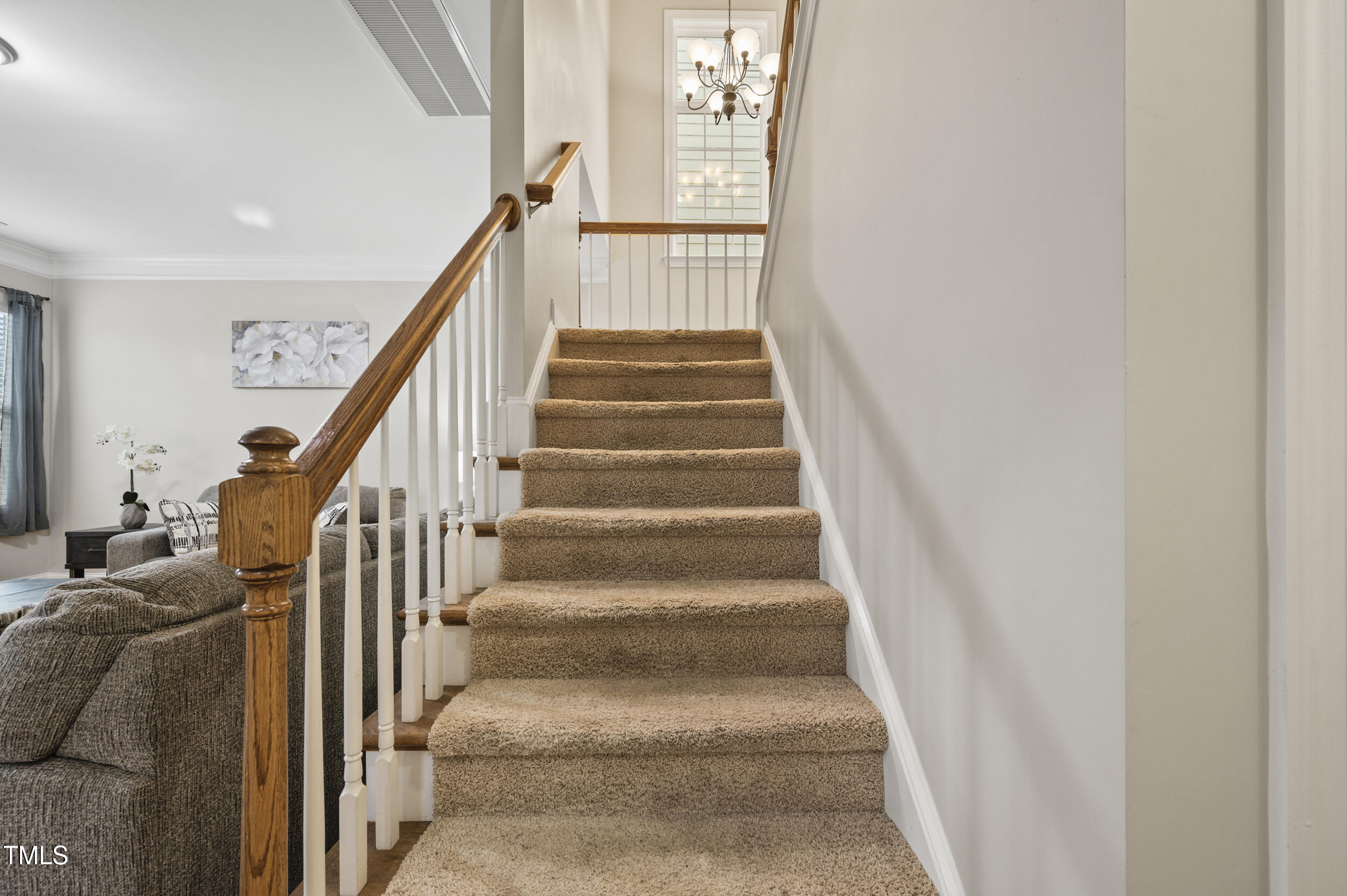 1204 Chapanoke Road Raleigh, NC 27603 - Photo 22 of 45 a view of staircase with lots of frames on wall and windows
