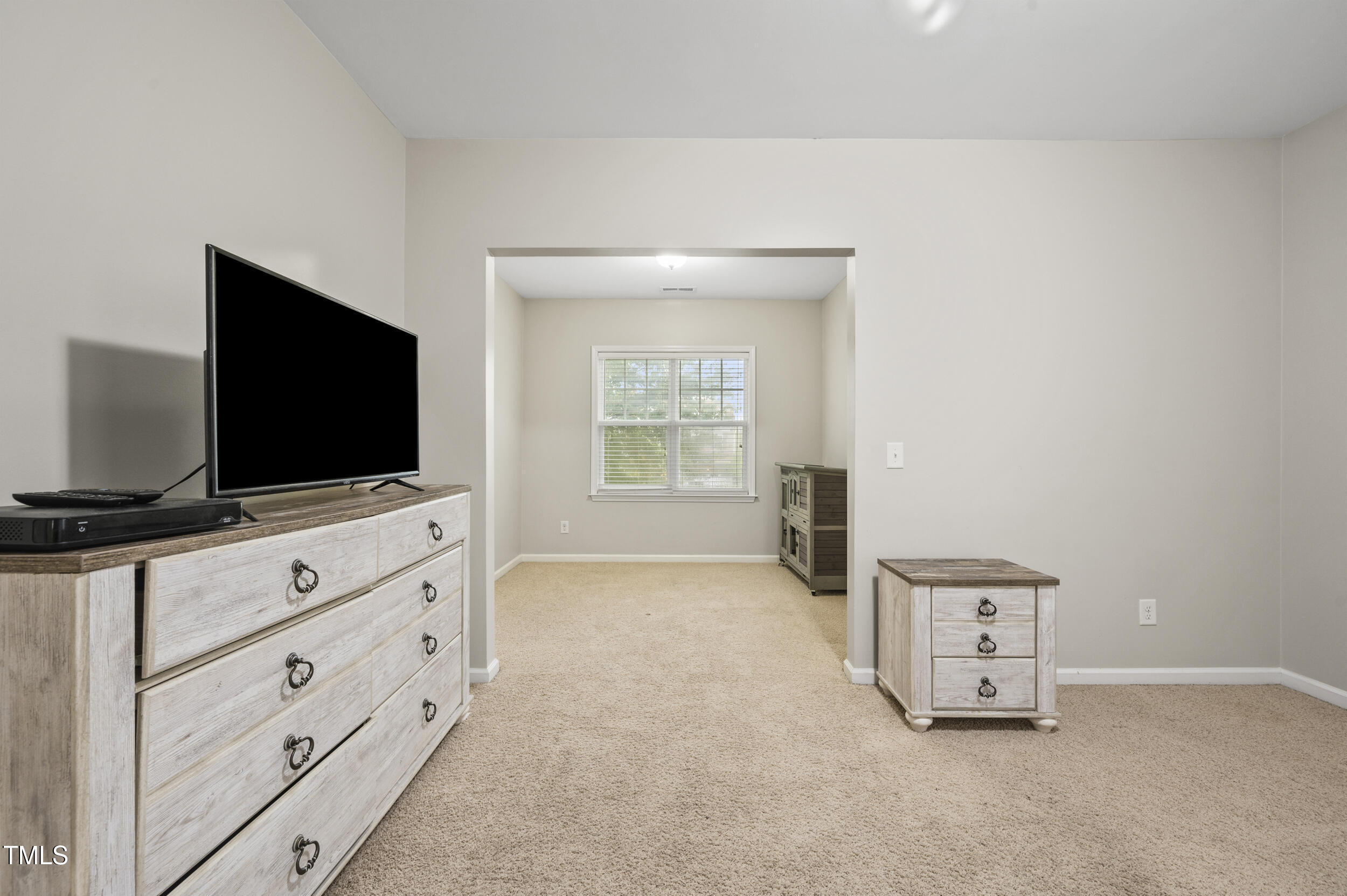 1204 Chapanoke Road Raleigh, NC 27603 - Photo 30 of 45 a living room with flat screen tv on dresser and a flat screen tv