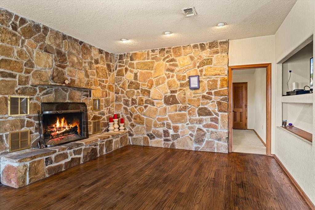 1601 Stafford Road Weatherford, TX 76088 - Photo 23 of 40 a living room with wooden floor and a fireplace