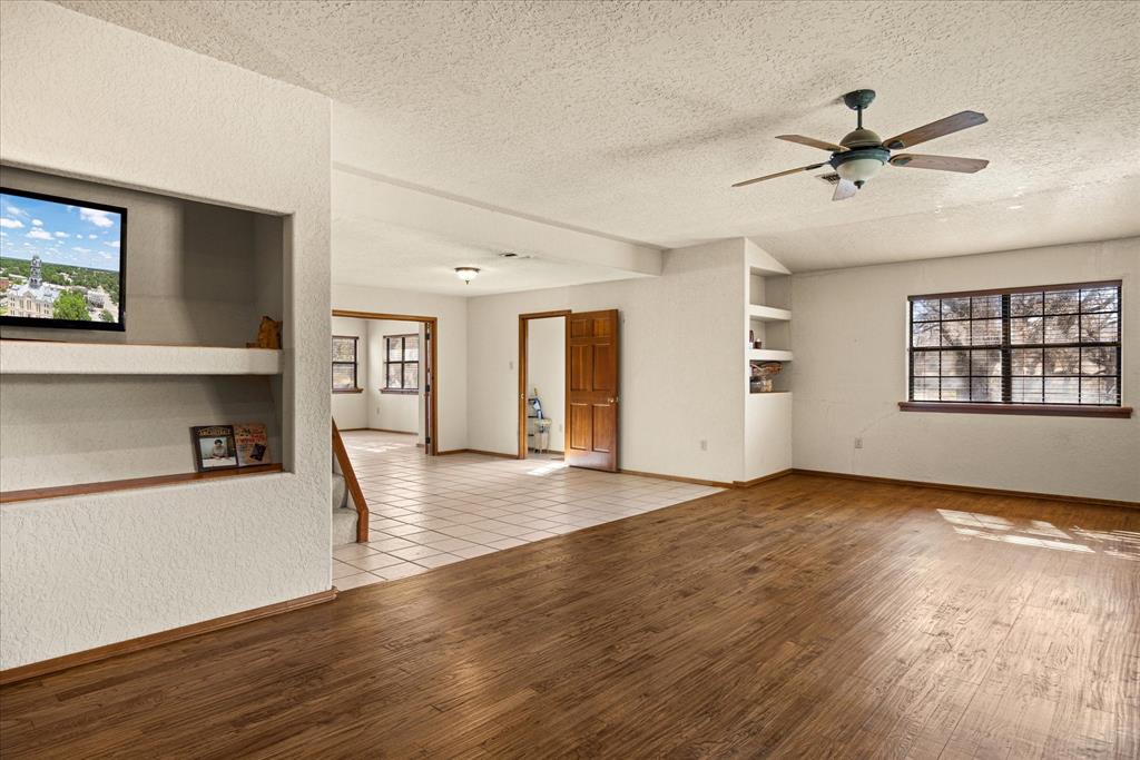 1601 Stafford Road Weatherford, TX 76088 - Photo 24 of 40 a view of a livingroom with wooden floor and a ceiling fan