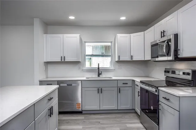 a kitchen with stainless steel appliances granite countertop a sink stove a microwave and cabinets