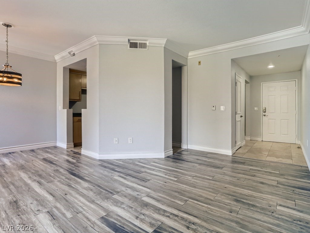 260 East Flamingo Road, Unit 220 Las Vegas, NV 89169 - Photo 7 of 32 Clean lines and wood-look flooring enhance this inviting open living area, featuring a peek into the kitchen.