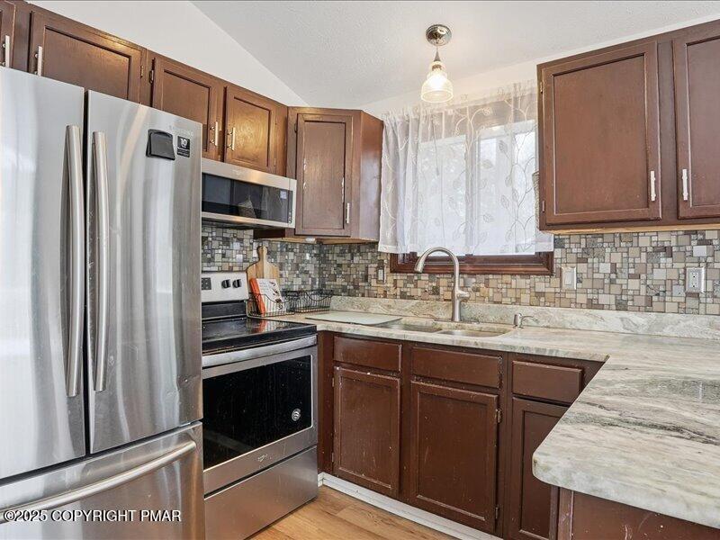 2167 Freedom Way Pocono Summit, PA 18346 - Photo 20 of 45 a kitchen with stainless steel appliances granite countertop a sink stove and refrigerator