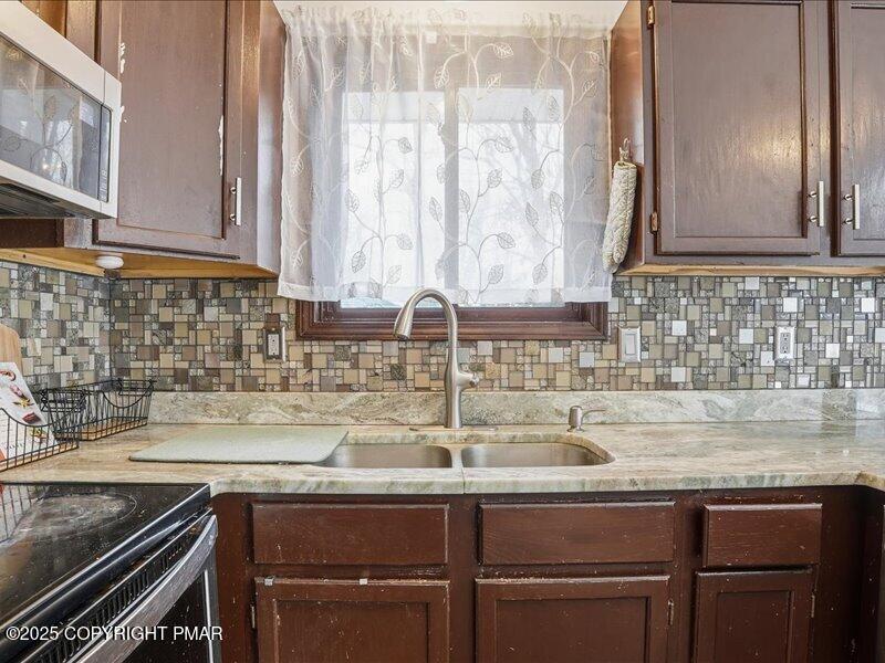2167 Freedom Way Pocono Summit, PA 18346 - Photo 21 of 45 a kitchen with stainless steel appliances granite countertop a sink and a white cabinets