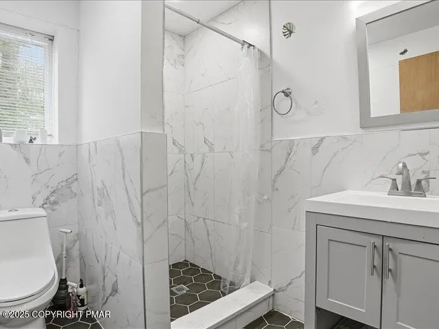 a view of an empty room with wooden floor and closet