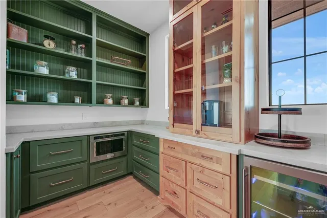 a kitchen with stainless steel appliances granite countertop wooden floors and white cabinets