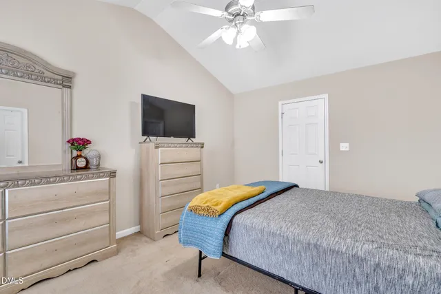 a bedroom with a bed and a flat tv screen on dresser