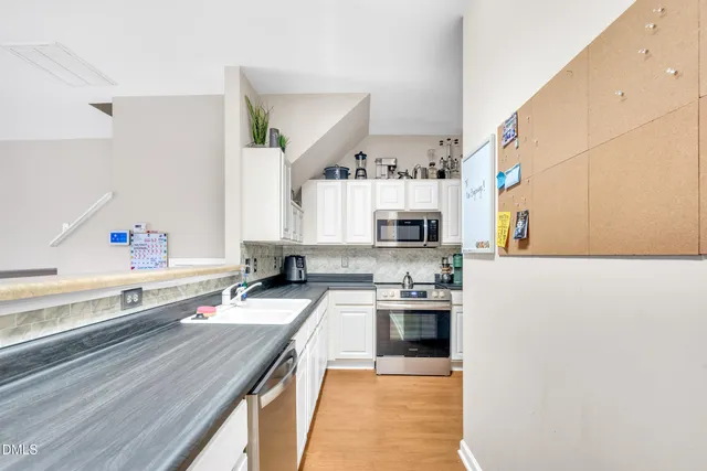 a kitchen with stainless steel appliances granite countertop a sink and cabinets