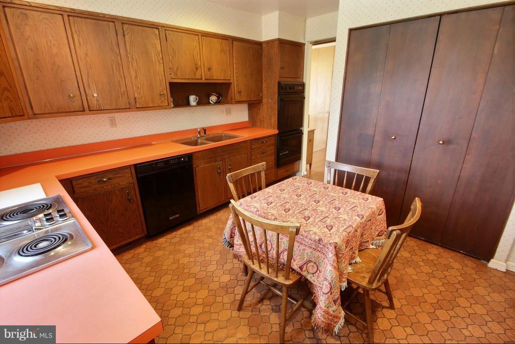 9119 Levelle Drive Chevy Chase, MD 20815 - Photo 10 of 30 a kitchen with stainless steel appliances a stove a refrigerator a sink and wooden cabinets