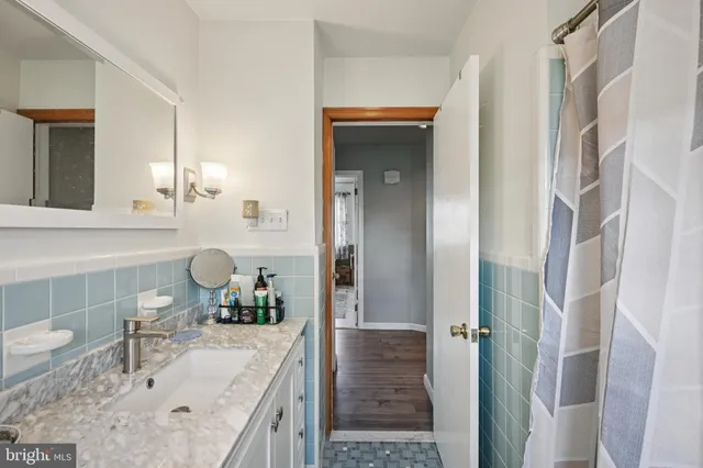 a bathroom with a granite countertop sink vanity and mirror
