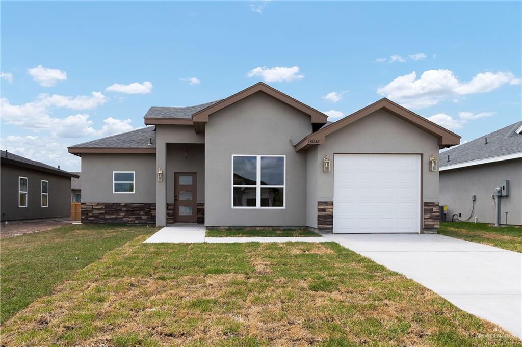 a front view of a house with a yard and garage
