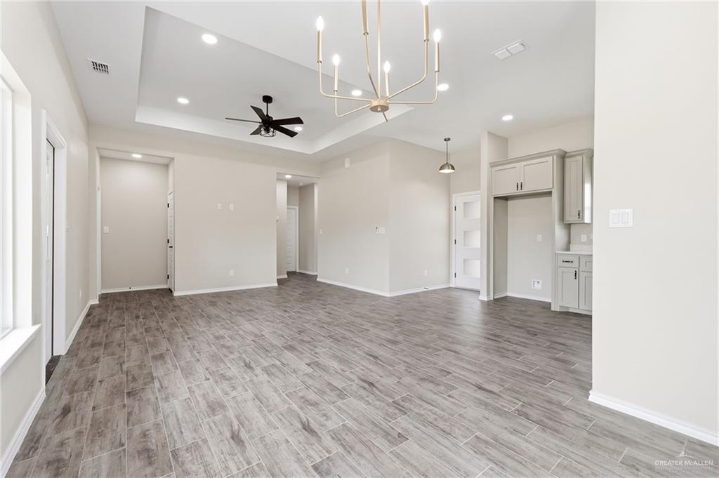 18032 Spruce Street Combes, TX 78552 - Photo 3 of 14 an empty room with wooden floor and a ceiling fan
