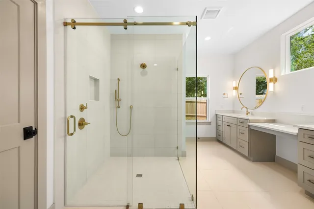 a spacious bathroom with a double vanity sink a mirror and a shower