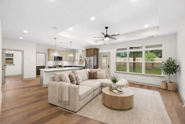 a large kitchen with stainless steel appliances kitchen island a large counter top and a wooden floors