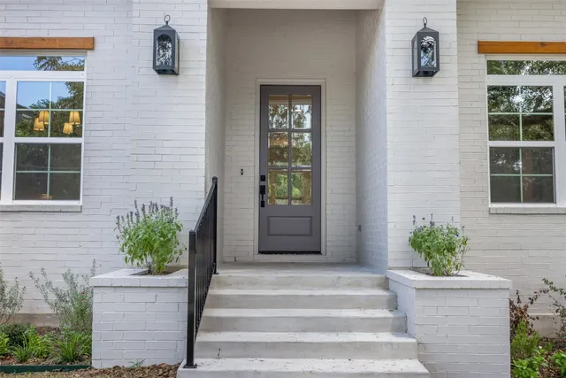 a front view of a house with potted plants