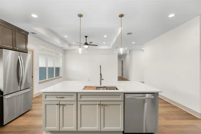 a view of a kitchen with a sink and refrigerator