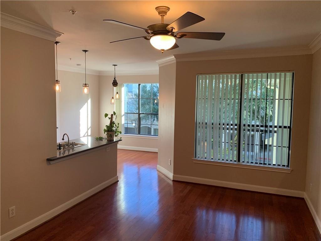 7701 Rialto Boulevard, Unit 1222 Austin, TX 78735 - Photo 14 of 14 Rich hardwood floors flow through this sun-drenched living space, highlighting an open floorplan with recessed lighting.