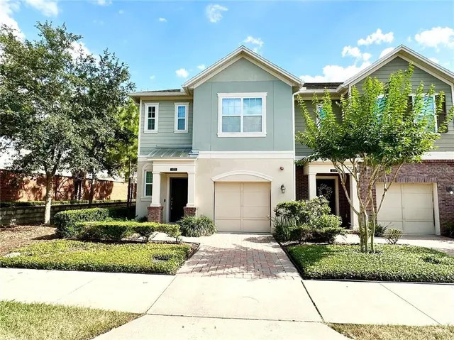 a front view of a house with a yard and potted plants