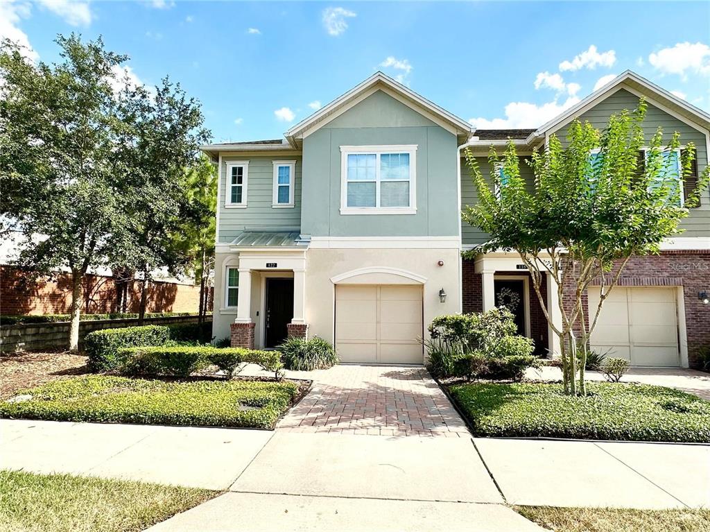 a front view of a house with a yard and potted plants