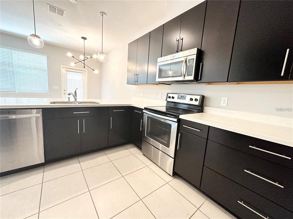 122 Zamora Place Oviedo, FL 32765 - Photo 2 of 23 a kitchen with a sink a stove top oven and cabinets