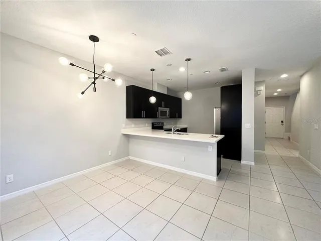 a large kitchen with a large counter top space appliances and a ceiling fan