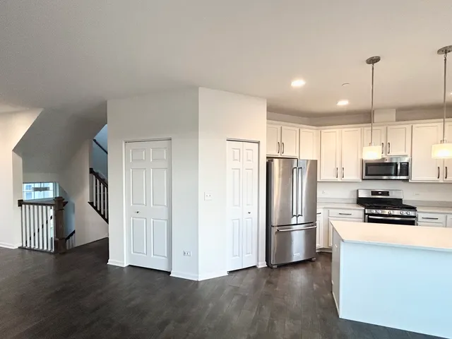 a kitchen with stainless steel appliances a refrigerator and a stove top oven