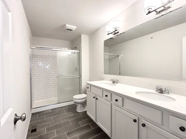 a bathroom with a granite countertop sink toilet and shower