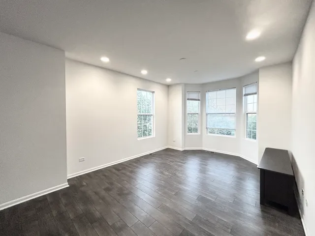 a view of a hallway with wooden floor and stairs