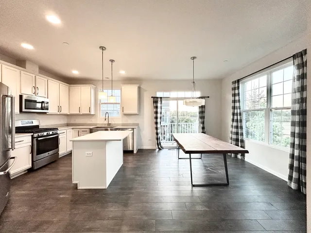 a kitchen with stainless steel appliances granite countertop a stove a sink a refrigerator and a microwave