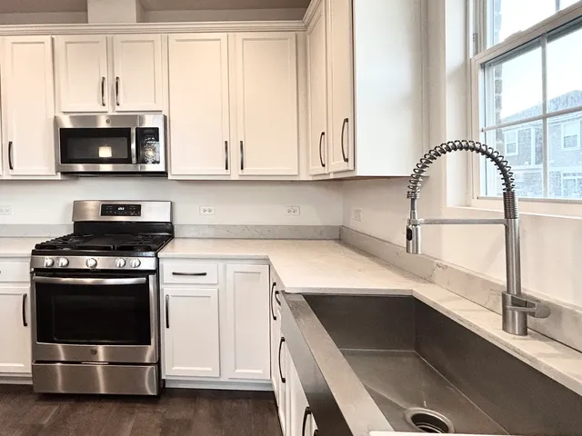 a kitchen with stainless steel appliances white cabinets and a sink