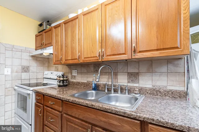 a kitchen with granite countertop a sink a stove and cabinets