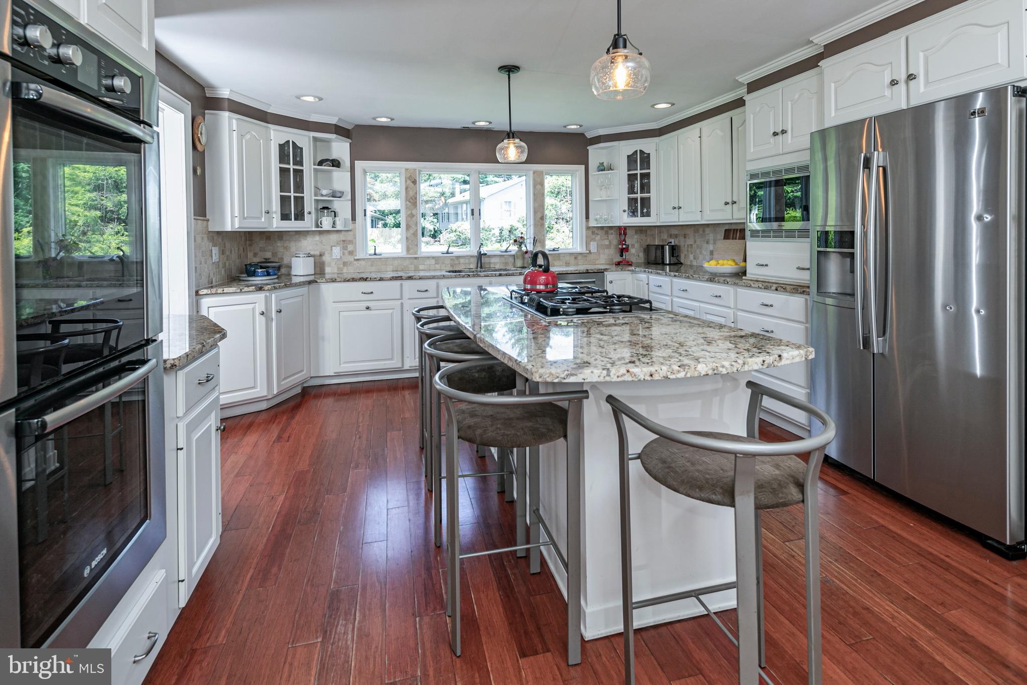 18 Mercer Street Hopewell, NJ 08525 - Photo 28 of 64 a kitchen with stainless steel appliances granite countertop a refrigerator a stove top oven a sink dishwasher and white cabinets with wooden floor