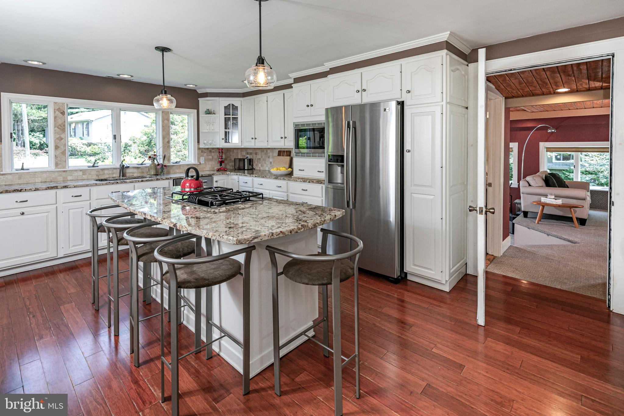 18 Mercer Street Hopewell, NJ 08525 - Photo 29 of 64 a kitchen with stainless steel appliances granite countertop a stove a refrigerator a sink dishwasher a dining table and chairs with wooden floor