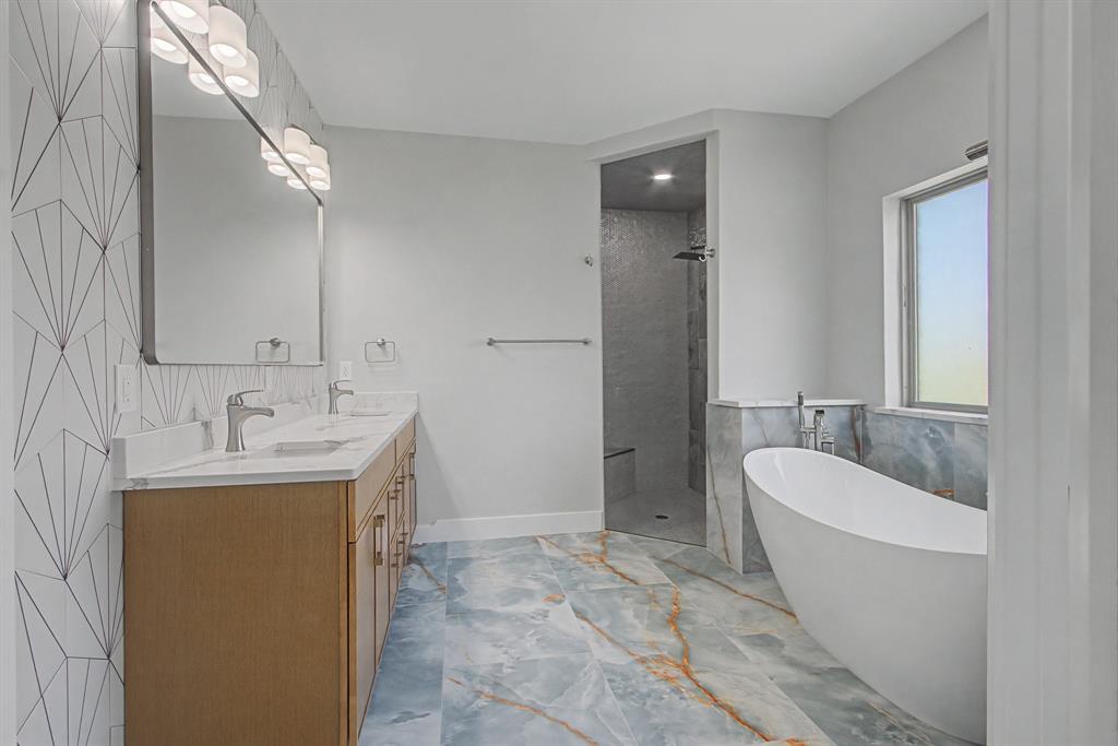 108 Winding Way Azle, TX 76020 - Photo 27 of 39 Full bathroom with tile walls, a soaking tub, double vanity, a walk in shower, and light marble finish floors
