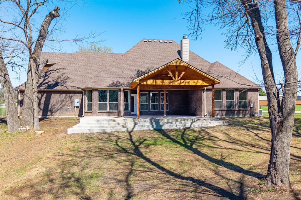 108 Winding Way Azle, TX 76020 - Photo 35 of 39 Back of house with a patio area, a chimney, brick siding, a lawn, and a shingled roof