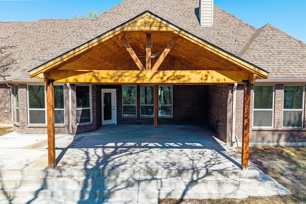 108 Winding Way Azle, TX 76020 - Photo 36 of 39 Back of property featuring a patio, a shingled roof, and brick siding