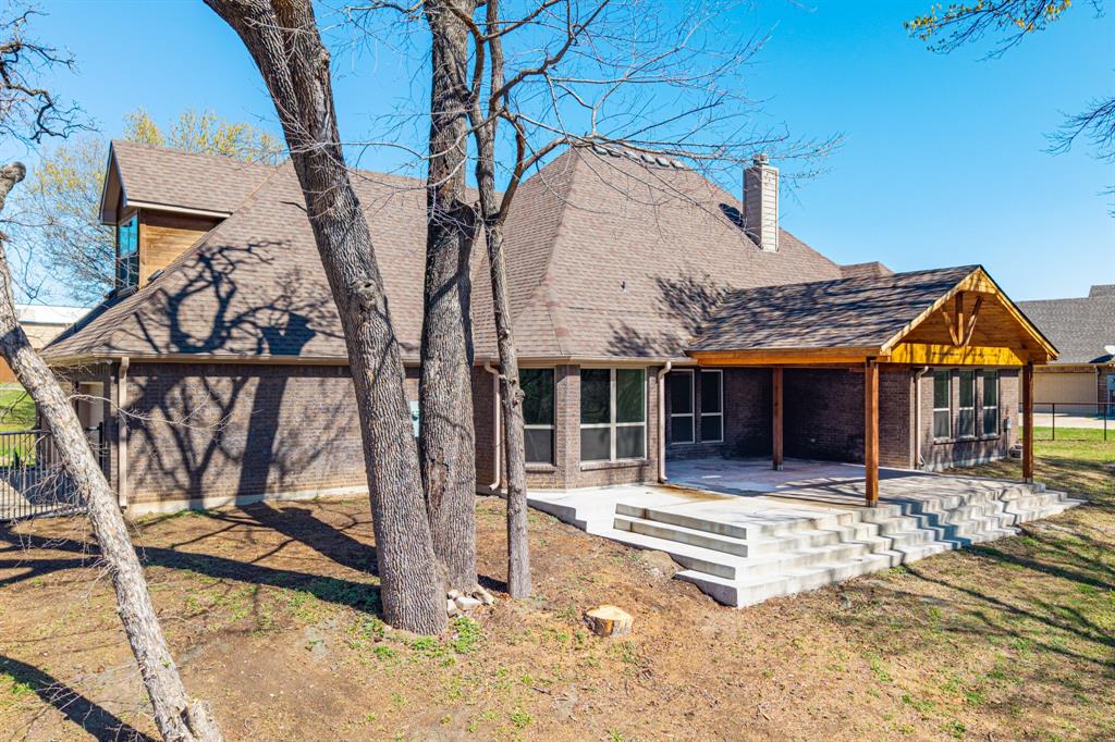 108 Winding Way Azle, TX 76020 - Photo 37 of 39 Rear view of house with roof with shingles, brick siding, a chimney, and a patio area