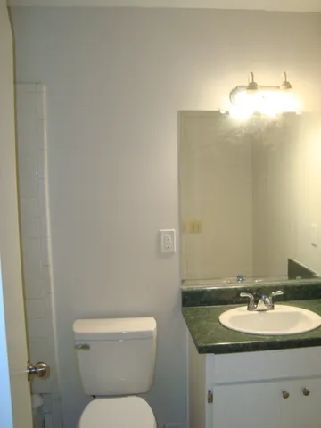 a bathroom with a toilet sink and mirror