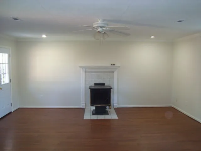 an empty room with a fireplace and wooden floor
