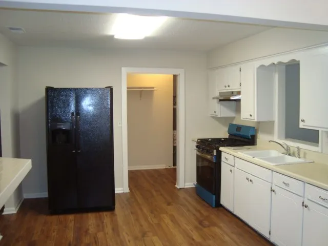 a kitchen with a refrigerator and a stove top oven